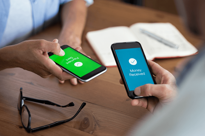 Two people holding phones. One shows payment sent and the other shows money received.