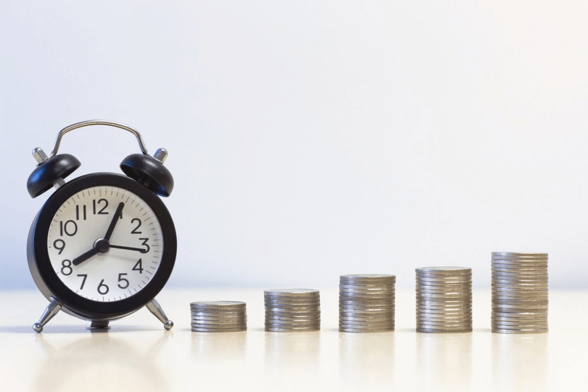 Money Sent in Minutes Small alarm clack and stacks of coins.